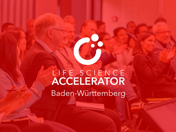 Publikum bei einer Veranstaltung des Life Science Accelerator Baden-Württemberg, mit dem Logo und Schriftzug im Vordergrund.